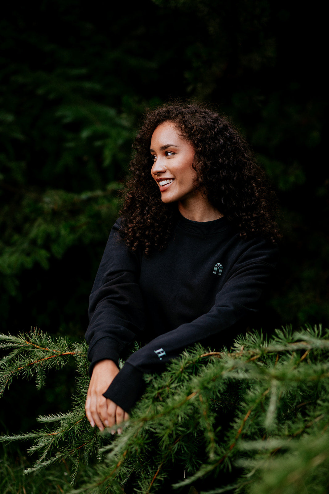 Close up of a woman wearing a black sweatshirt in a forest