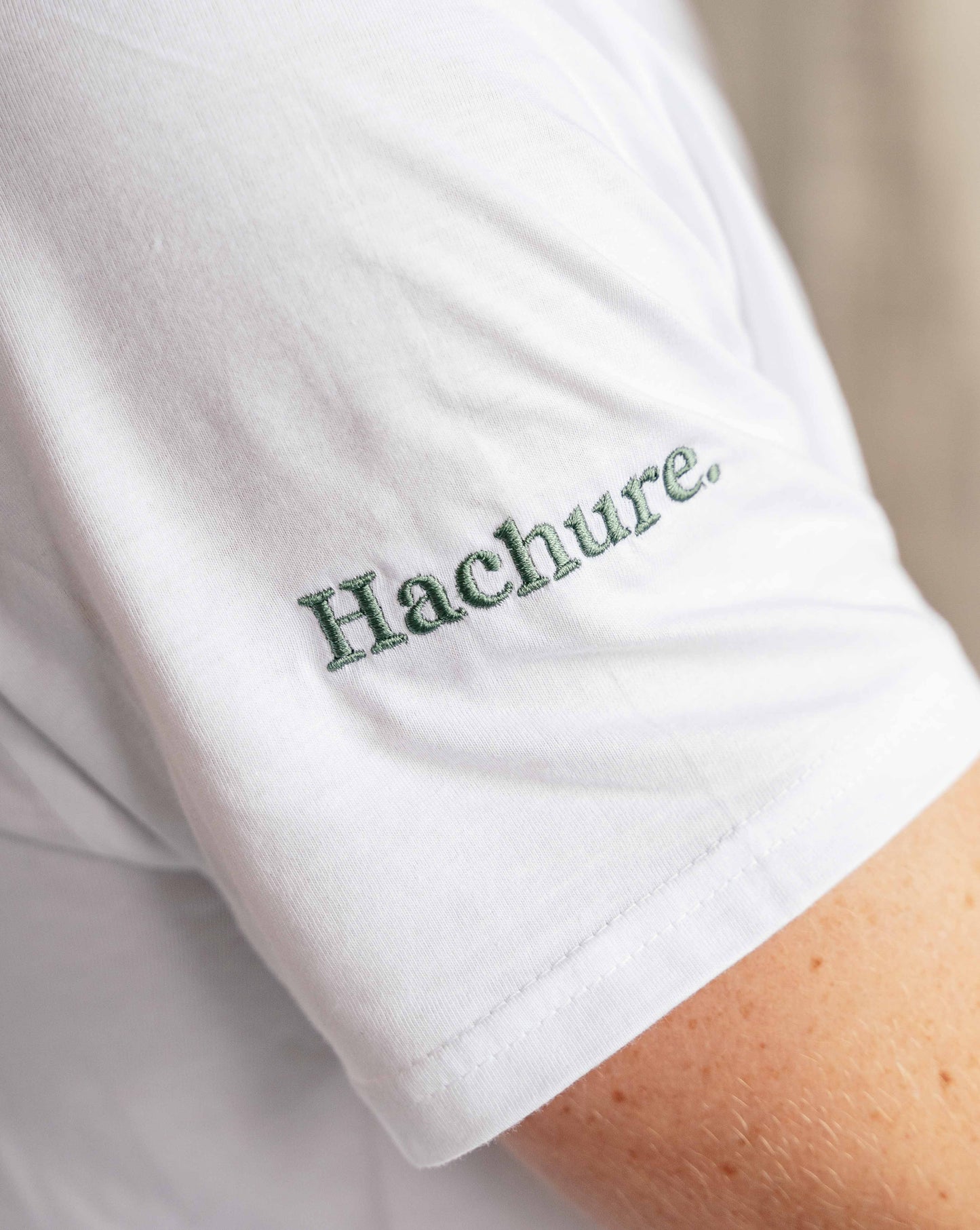 Close up of logo embroidery on the sleeve of a Hachure t-shirt 