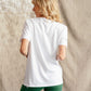 Woman wearing Hachure Active white t-shirt with green logo embroidery 