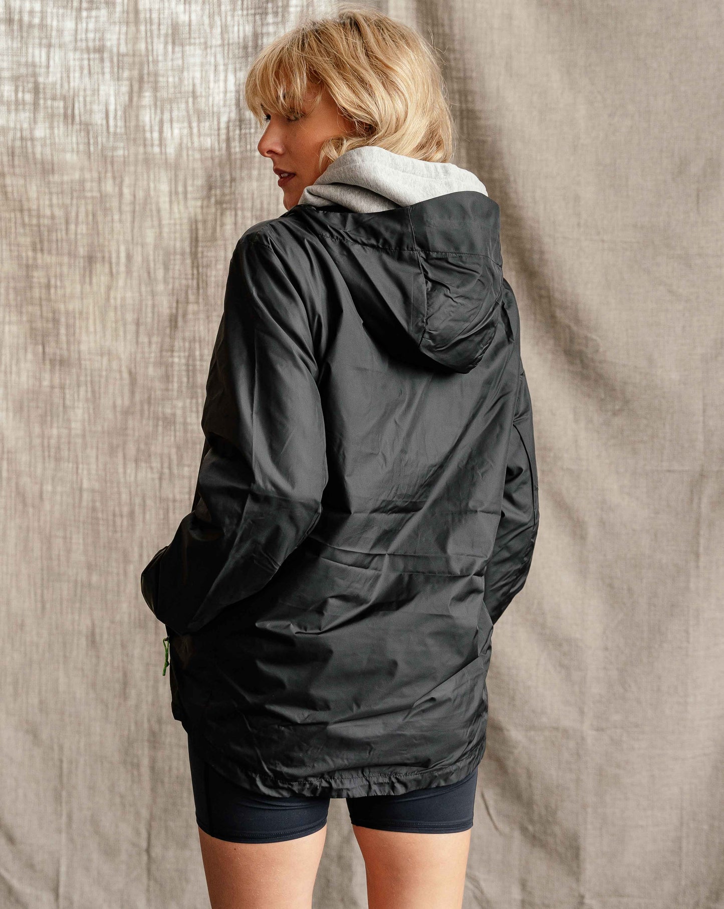 Woman wearing Hachure Mountains full zip windbreaker in black back view