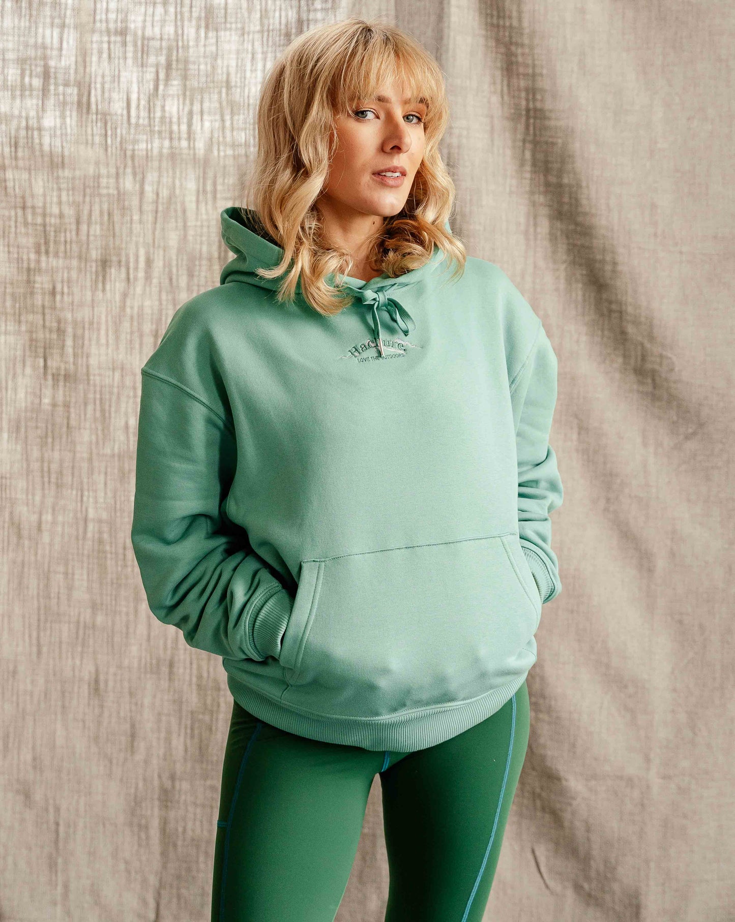 Woman wears Hachure Wilder hoodie in mint green 